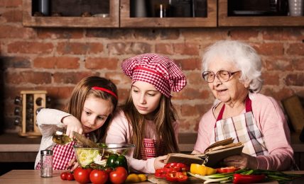 Dos niñas siguen una receta con su abuela