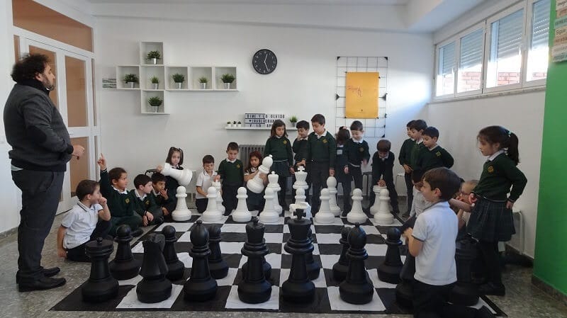Niños juegan al ajedrez en el aula todos juntos