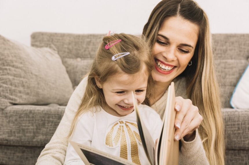 Cheerful Mother And Daughter Reading Book Near Sofa